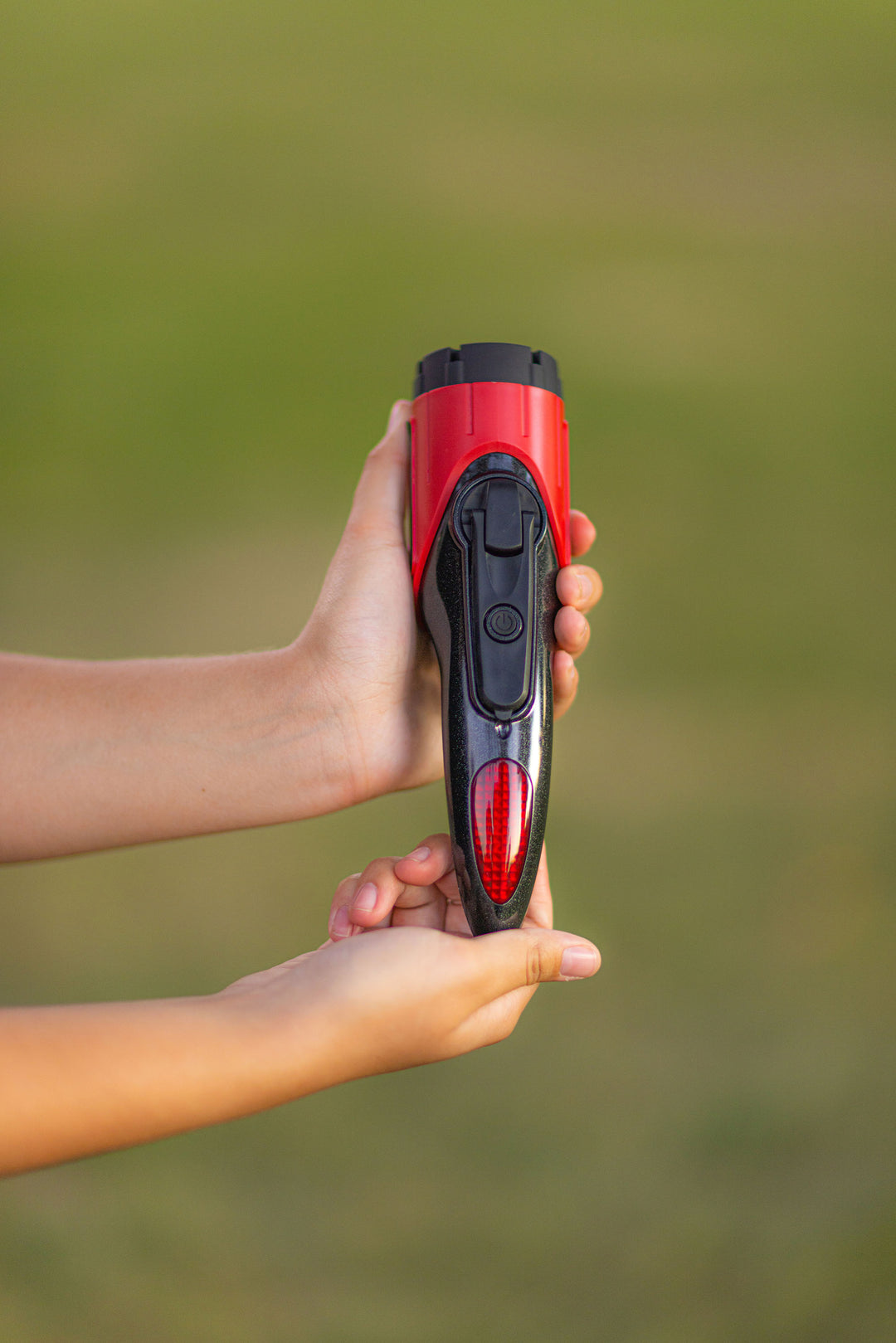 Car and truck rescue flashlight with siren and seatbelt cutter being held by person. Compact and easy to store auto rescue tool.