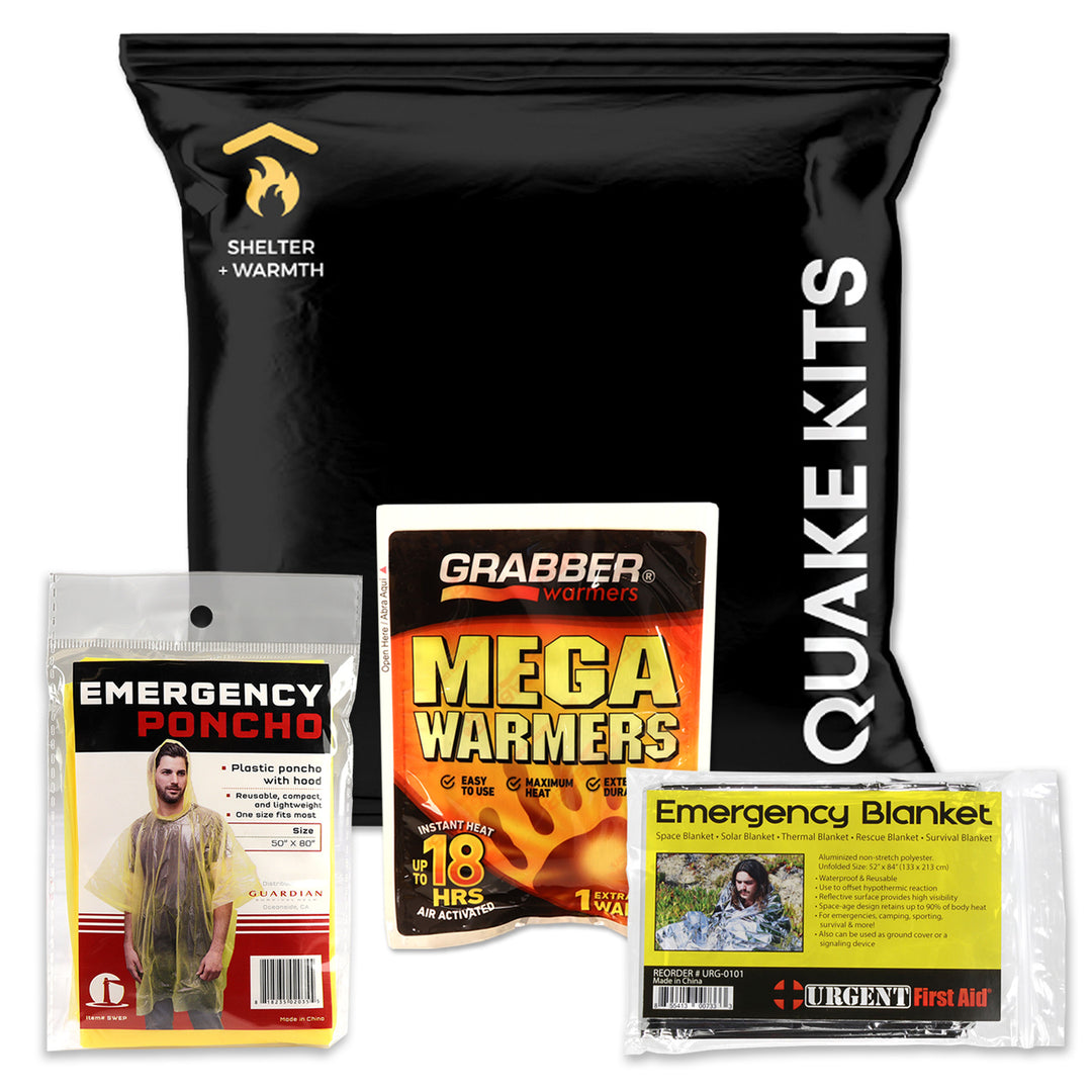 Emergency preparedness kit bundle featuring a large black bag labeled 'QUAKE KITS' with a Shelter + Warmth logo, a Grabber Warmers 'Mega Warmers' pack, an Emergency Poncho package, and an Urgent First Aid 'Emergency Blanket' package, all on a white background.