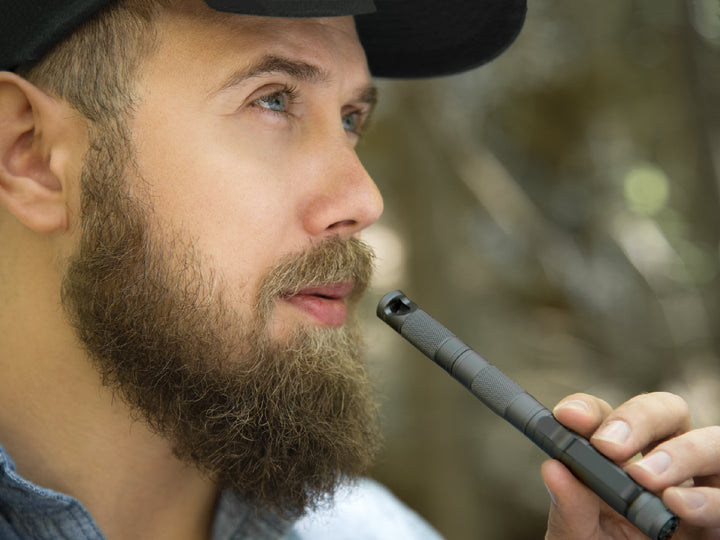 Emergency whistle tool being used in the outdoors