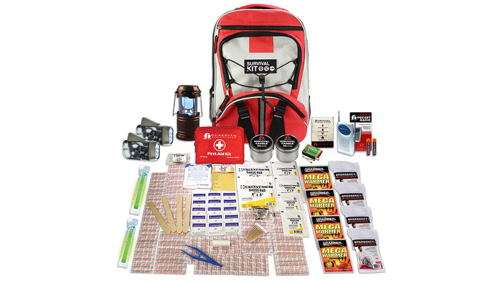 QuakeKits® SKB4 Family Blackout Kit displayed with all emergency supplies organized around a durable red-and-gray backpack. Contents include a 107-piece first aid kit, solar lantern, AM/FM emergency radio, two dynamo flashlights, waterproof matches, emergency glow sticks, emergency candles, four body warmers, four Mylar sleeping bags, and survival accessories. Designed to provide emergency light, warmth, communication, and first aid during power outages, winter storms, and family emergencies.